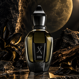 A bottle of Xerjoff Duran Duran perfume displayed on a dark reflective surface with black rocks and a large moon in the background. The bottle is dark amber glass with a glossy black cap and a black front label featuring the Xerjoff logo and the fragrance name 'DURAN DURAN'.