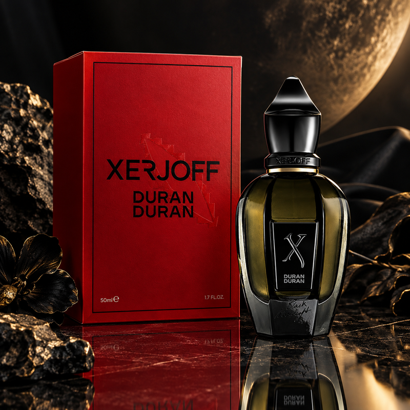 Xerjoff Duran Duran perfume bottle and its red packaging box, styled on a dark reflective surface with gold-toned rocks and fabric.