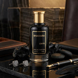 "Bharara ONYX EDP Spray 3.4oz for Men black perfume bottle displayed on a dark wooden table."