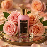 "Bharara Rose EDP Spray 100ml perfume bottle displayed among pink roses."