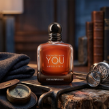 "Emporio Armani STRONGER WITH YOU ABSOLUTELY Parfum Spray 1.7oz / 50ml perfume bottle displayed in an elegant dark decorative setting."