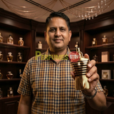"Perfumes Stop owner holding a bottle of Jean Paul Gaultier Le Male Elixir Parfum Spray 2.5 oz / 75ml."