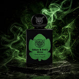 "A black perfume bottle labeled 'Adam & Eve's Dress' by Lorenzo Pazzaglia, featuring a green label and cap, set against a dramatic dark green background with swirling smoke and soft lighting."