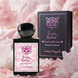 "A bottle of Lorenzo Pazzaglia Sugar Kisses Extrait de Parfum with its matching black packaging box, featuring a pink butterfly graphic and pink label, set against a soft pink floral background with warm lighting."