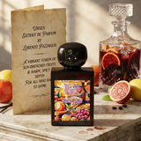 "A black perfume bottle labeled 'Sun-Gria' by Lorenzo Pazzaglia, with a colorful red and orange label, set against a bright background with citrus fruits, grapes, and red wine."