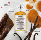 "A perfume bottle labeled 'Replica Jazz Club' by Maison Margiela, styled with pink pepper, neroli, rum, sage, tobacco leaf, and vanilla against a warm background with citrus fruits, spices, and soft lighting."