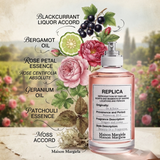 "A perfume bottle labeled 'Replica On A Date' by Maison Margiela, styled with blackcurrant, bergamot, pink pepper, rose, geranium, davana, patchouli, vetiver, oakmoss, and musk against a bright floral background with grapes, flowers, and soft natural lighting."