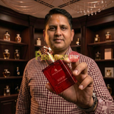 "Perfumes Stop owner holding a bottle of Swiss Arabian Rose 01 Extrait de Parfum"