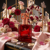 "A red perfume bottle labeled 'Rose 01' by Swiss Arabian, displayed on a table surrounded by pink roses and decorative flowers against a warm, elegant background with soft lighting."