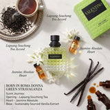 "A perfume bottle labeled 'Born in Roma Donna Green Stravaganza' by Valentino, styled with green tea leaves, jasmine, vanilla, and other fragrance ingredients against a fresh green background with soft lighting."