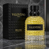 "A perfume bottle labeled 'Born in Roma Uomo Yellow Dream' by Valentino, styled with Italian tangerine, Mexican lime, pineapple, lavender, geranium, gingerbread, Madagascar vanilla, amber, and Virginia cedar against a dramatic dark background with citrus fruits and warm golden lighting."